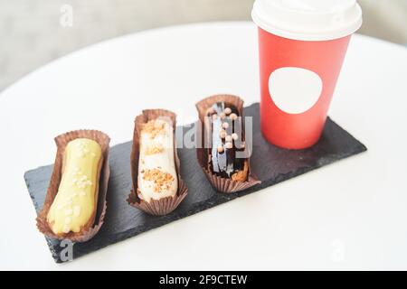 Three eclairs on a black tray top view Stock Photo