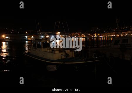 Pilot boat moored in a port at night Stock Photo