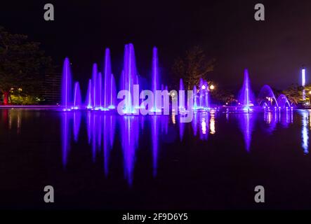 Time lapse photo of a colourful fountain at night - shades of purple and blue Stock Photo