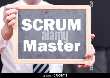 Businessman wearing a suit and holding a blackboard with the phrase SCRUM and SPRINT written on it Stock Photo
