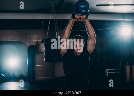 Young athlete has workout and doing sport exercises with kettlebell Stock Photo