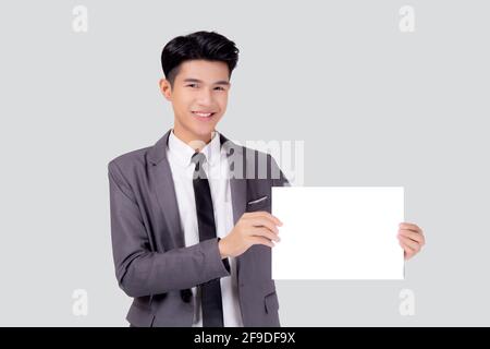 Young asian business man showing empty signboard for advertising isolated on white background, businessman confident holding billboard banner for pres Stock Photo