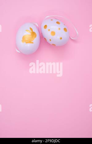A vertical shot of decorative Easter egg decorations on a pink surface Stock Photo