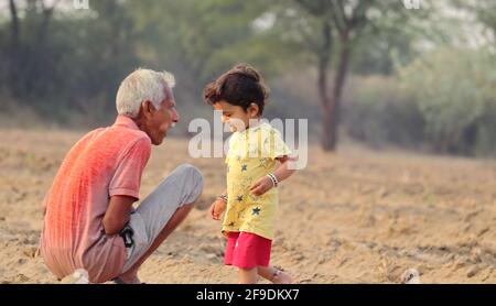 Close-up of Senior Grandpa and little indian grandson talking together in the farm Stock Photo
