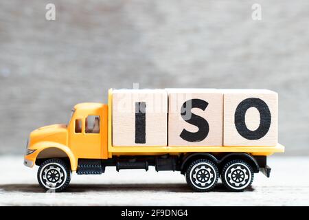 Truck hold letter block in word ISO on wood background Stock Photo