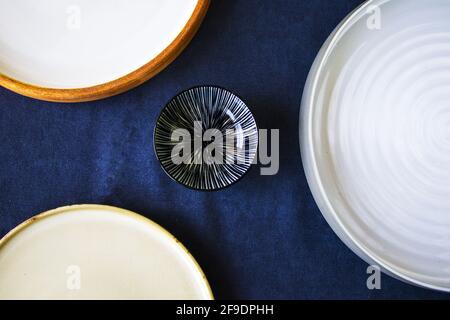 A top view shot of Empty bowls and plates on the blue background Stock Photo