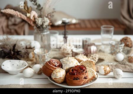 Fresh homemade Easter baked goods on the holiday table with decor details on blurred background. Stock Photo