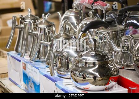 A closeup of metal kettles and teapots on boxes in a shop with a blurry background Stock Photo
