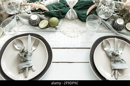 Festive table setting at home with Scandinavian decorative details close up. Stock Photo