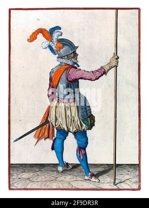 A soldier, full-length, seen from the back, holding a spear (lance) upright with his right hand. This is the third act of bringing the skewer upright Stock Photo