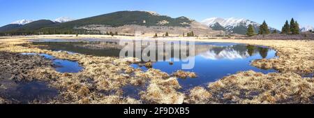 Scenic Panoramic Landscape View Prairie Grassland and Mountain Peak Blue Lake Reflection. Ya Ha Tinda Ranch, Alberta Foothills, Canadian Rockies Stock Photo