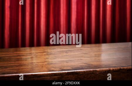 wood diagonal table with red red curtain wall blur background.Mock up  banner for display of product Stock Photo