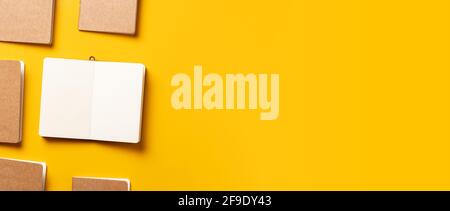 content marketing concept,.top view of hand writing on open notebook align with kraft paper book in pattern on yellow table background.mockup for adve Stock Photo