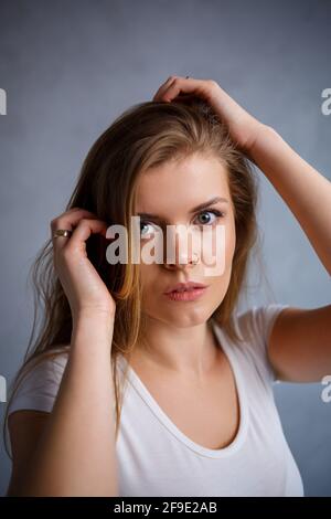 Close up portrait of a beautiful young woman. Emotional photo of a girl. Dressed in a white t-shirt Stock Photo