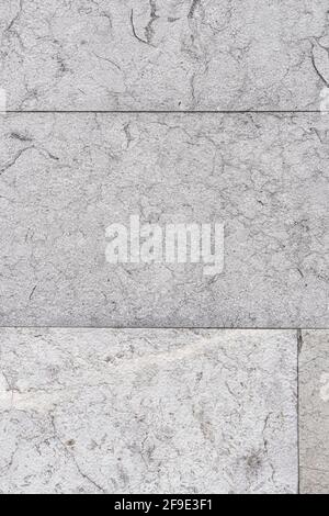 Close-up of cracked gray wall tiles with cracks and seams. Abstract vertical background Stock Photo