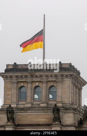 Berlin, Germany. 18th Apr, 2021. The German flag on top of the Reichstag building flies at half-mast on the occasion of the central memorial for those who died in the Corona pandemic in Germany. Credit: Christoph Soeder/dpa/Alamy Live News Stock Photo