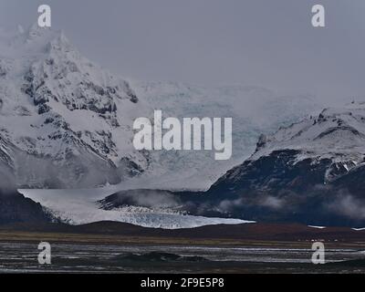 Stunning view of majestic Svínafellsjökull, an outlet glacier of Vatnajökull in southern Iceland, with steep ice fall surrounded by rough mountains. Stock Photo