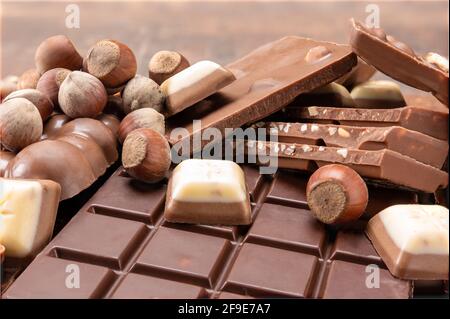 Chocolate bars with nuts. Top view of chocolate bar with hazelnuts. Chocolate background. Bars and strips of chocolate. Heap of broken choco pieces an Stock Photo