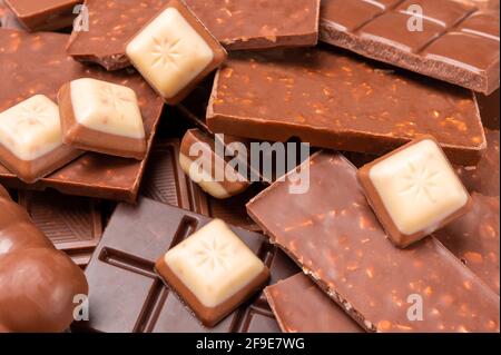 Top view of pieces of chocolate bar with chocolate chips on rustic wooden background. Milk chocolate chunks. Assorted chocolate. copy space Stock Photo