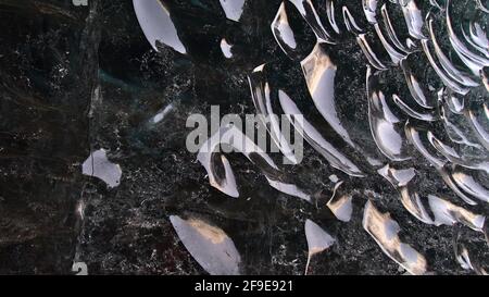 Bizarre ice formations with clear, smoothed icy surface and reflections in wall of the Sapphire Ice Cave in Breiðamerkurjökull glacier, Vatnajökull. Stock Photo