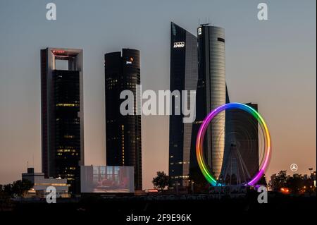 Madrid, Spain. 17th Apr, 2021. A recently installed Ferris wheel turns illuminated during a movie screening at the drive-in cinema (Autocines Race Madrid) with the view of the skyline with the skyscrapers of the Four Towers Business Area. Credit: Marcos del Mazo/Alamy Live News Stock Photo
