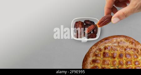 Typical of the month of Ramadan for muslims is the setting here, after the fast has been broken - pita bread and pitted dates. Traditional iftar food. Stock Photo