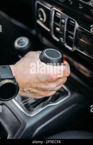 Crop view of anonymous man with her hand on the gear shift of an off-road car Stock Photo