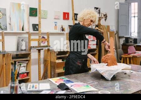 Female ceramist using clay and creating handmade earthenware in art studio Stock Photo