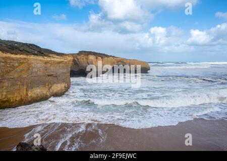 Strong ocean waves and London Bridge rock formation on the famous Great Ocean Road in Victoria, Australia Stock Photo