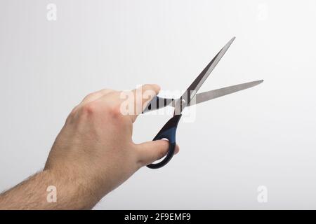Stationery scissors in hand isolated on a white background. Stock Photo