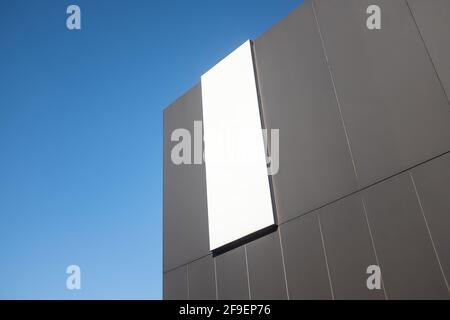 A Sign On The Side Of A Modern Commercial Retail Building, Blank For Your Text, With Blue Sky And Copy Space Stock Photo