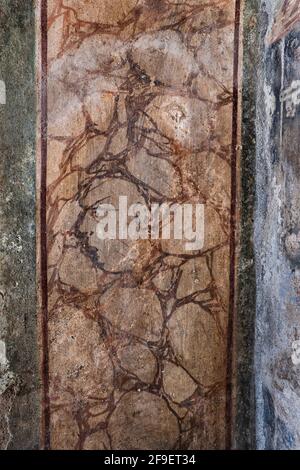 Hidden face on Lararium side in House of the Golden Cupids in ancient Roman city of Pompeii, Campania, Italy Stock Photo