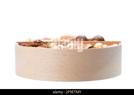 wooden round gift container with triangular cells and mix of different types of nuts for a healthy protein diet side veiw isolated on white background Stock Photo