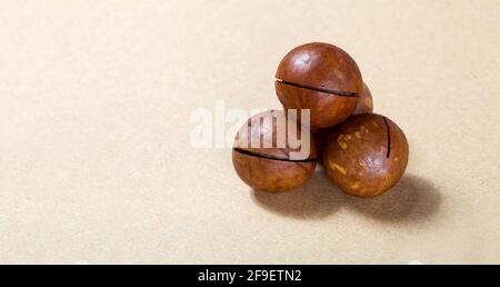 macadamia nuts bunch of ripe nutritious proteins in a ripe harvest on a brown background food for vegetarians, nobody. Stock Photo