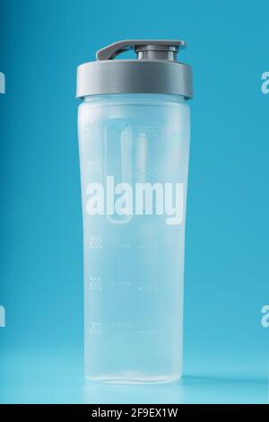 Shaker is an empty plastic smoothie cup on a blue background. Free space, minimalistic concept Stock Photo