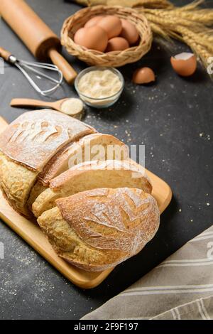 freshly baked sourdough bread with fresh egg and accessories bakery on black table, Stock Photo