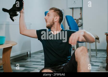 BRCKO, BOSNIA AND HERZEGOVINA - Sep 08, 2018: Shot of man playing with cat at home Stock Photo