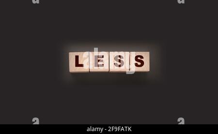 Less word on wooden cubic blocks. Spend less or cut costs business concept. Stock Photo