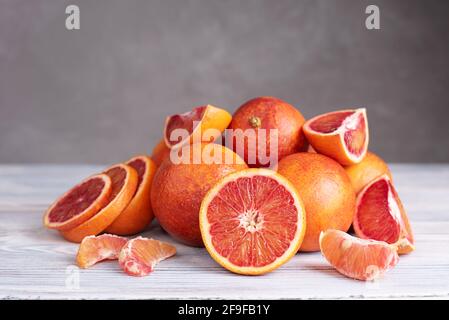 The batch of fresh juicy blood orange on gray wooden background, healthy food, close up. Stock Photo
