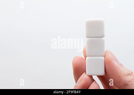 Three vertically stacked white cubes with nothing written on them Stock Photo