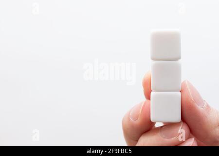 Three vertically stacked white cubes with nothing written on them Stock Photo