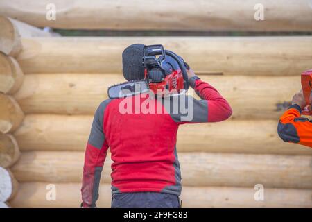 A worker holding a chainsaw in construction area Stock Photo