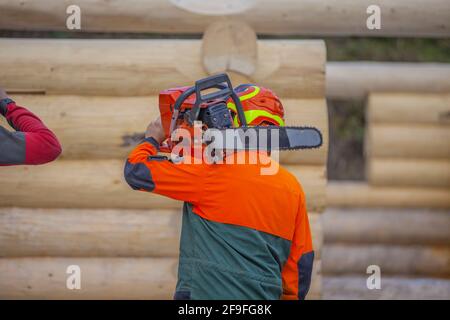 A worker holding a chainsaw in construction area Stock Photo