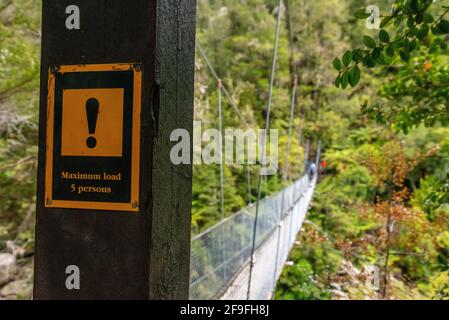 Nz Track Sign Warning signs about a suspension footbridge in Abel Tasman Cost Track ...
