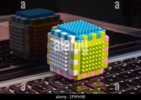 Colorful building sets on a laptop keyboard and its reflection, education concept Stock Photo