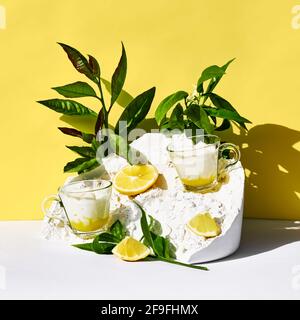 Lemon mousse or ice cream in a glass cups on yellow background. Traditional Italian recipe of lemon tiramisu or granita. Delicious summer desserts. Stock Photo