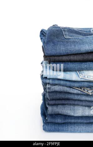Stack of blue jeans isolated on white background. Fashion clothing concept. Stock Photo