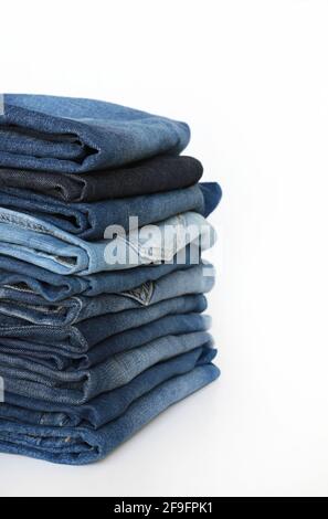 Stack of blue jeans isolated on white background. Fashion clothing concept. Stock Photo