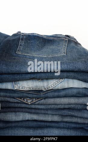 Stack of blue jeans isolated on white background. Fashion clothing concept. Stock Photo