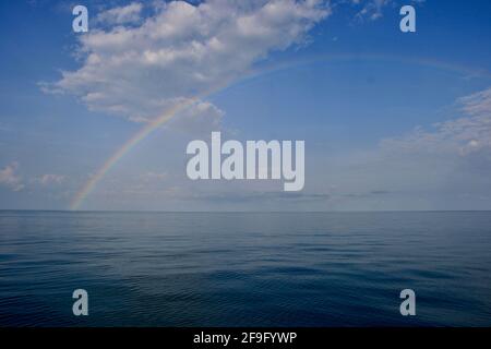 Tropical rainbow over a glassy ocean Stock Photo